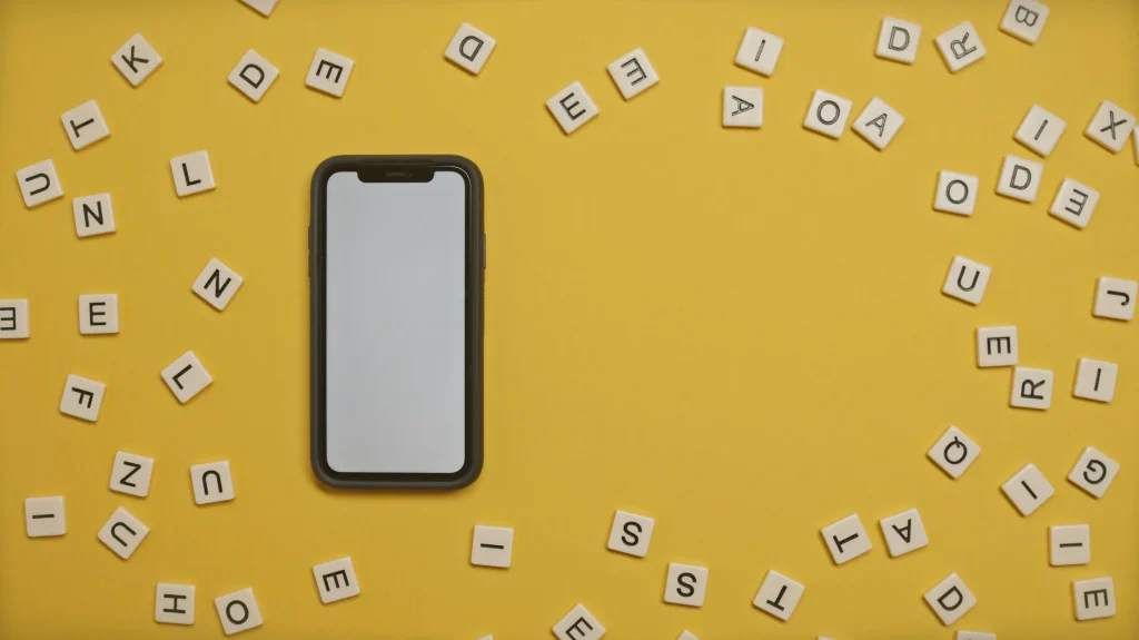 Auf einem orangefarbenen Hintergrund ist ein Mobiltelefon zu sehen, das von Buchstaben umgeben ist.